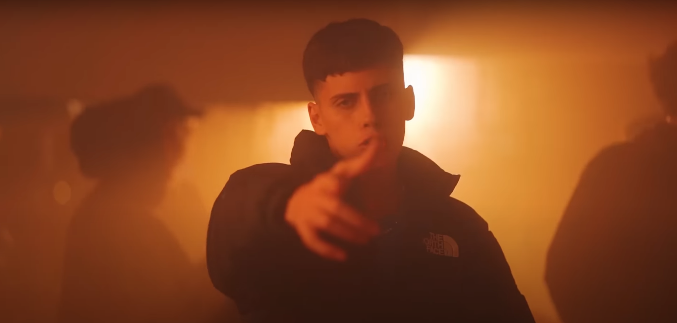 fotografía de James Rosello señalando a la cámara con su mano derecha, con un tinte naranja